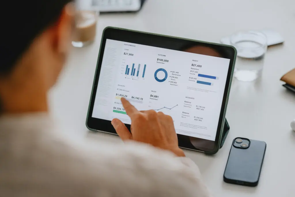 Person analyzing business data on a tablet.