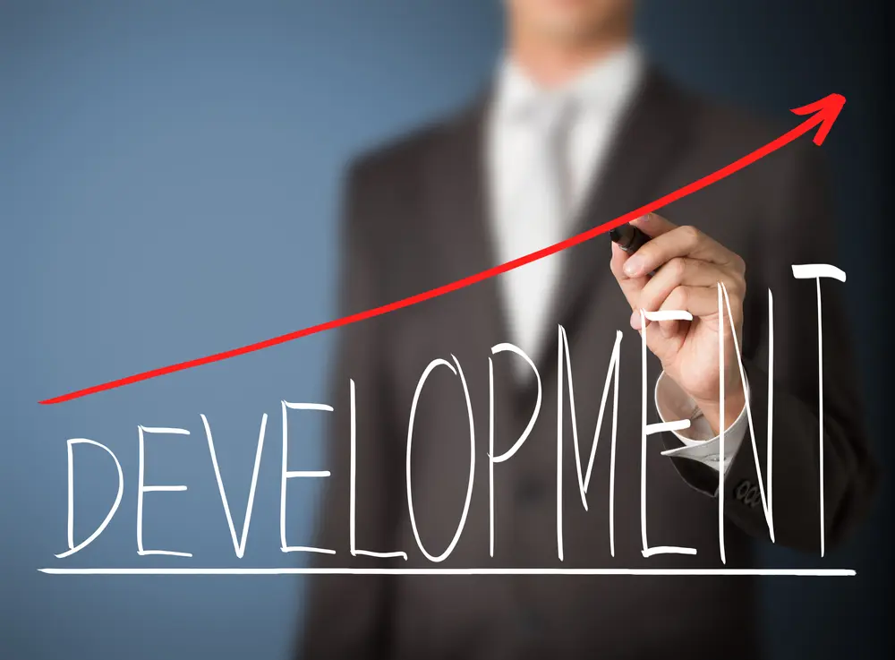 Businessman drawing a rising development graph.