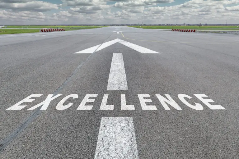 A road with an arrow and the word 'EXCELLENCE' painted on it.