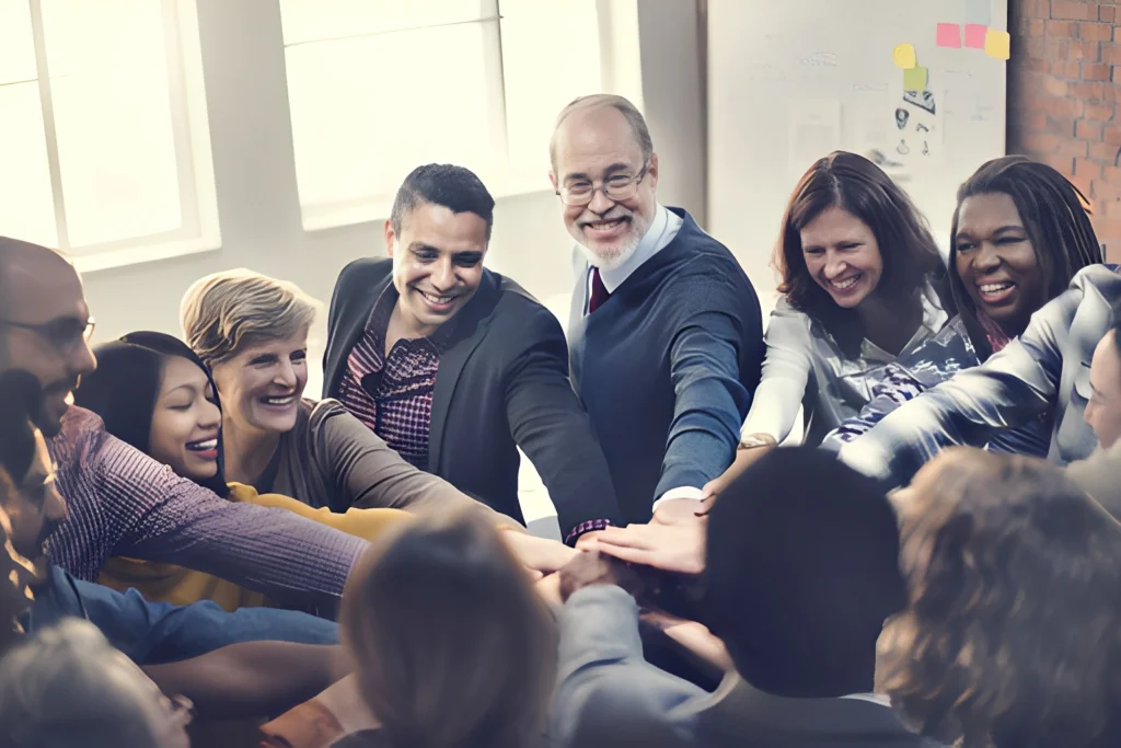 A diverse group sharing a team-building moment with hands together.