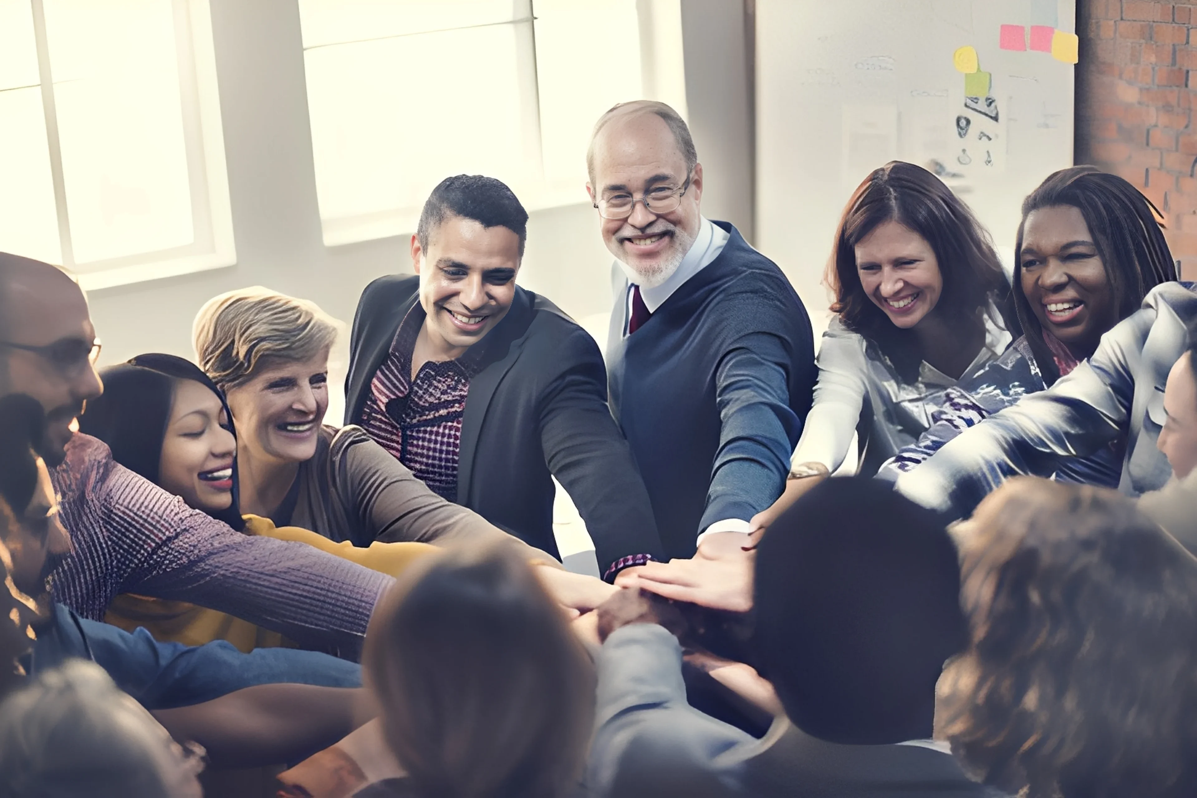A diverse group sharing a team-building moment with hands together.